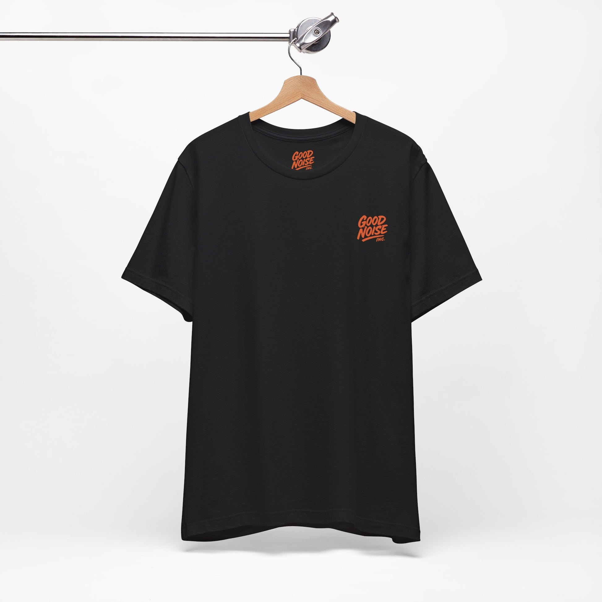 Black t-shirt with orange logo on a hanger against a white background